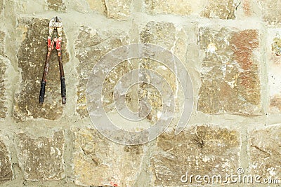 Old moldy stone wall with work scissors. Stock Photo
