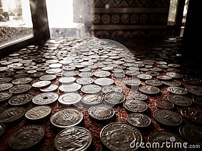 Old money coins collection behind window with sunlight in the background Editorial Stock Photo