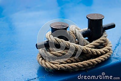 Old mooring bollard with heavy ropes Stock Photo