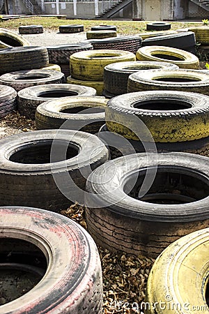 Old multi-colored tires scattered on asphalt and yellow leaves Editorial Stock Photo