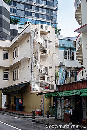 Old neglected white and blue buildings in Little India District in Singapore with spiral staircases and worn out paint Editorial Stock Photo