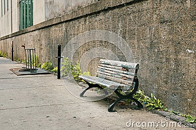 Old obsolete wooden bench on the sidewalk Stock Photo