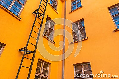 Old orange industrial building with fire escape leading Stock Photo