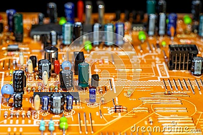Old orange printed circuit board with multi-colored electronic components Stock Photo
