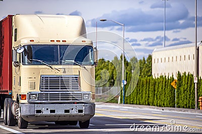 Old over engine cab big rig semi truck transporting container on the street road Stock Photo