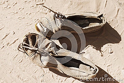 Old pair of shoes on sand Stock Photo