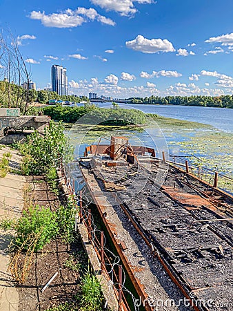 An old, partially submerged dilapidated structure with rusted metal elements is depicted in a lagoon or shallow water Editorial Stock Photo