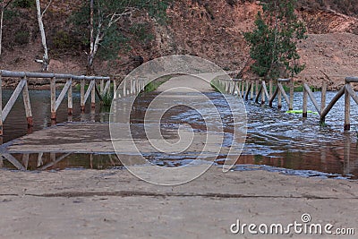 Old partially sunken wooden bridge over a tranquil lake Stock Photo