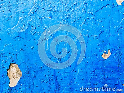 Old, peeling blue paint on the wall is painted on top of a darker blue paint. Stock Photo
