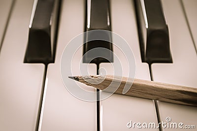 Old Pencil on White Keys of Electric Piano in Crosswise View and Vintage Tone Stock Photo