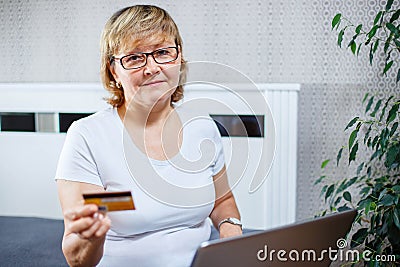 Old people and modern technology concept. Portrait of a 50s mature woman hand holding credit card Stock Photo