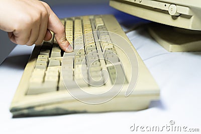 Old personal computer with man Entering Enter Button a keyboard. Stock Photo
