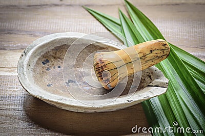 Old pharmacy mortar and ivory pestle with herb Stock Photo
