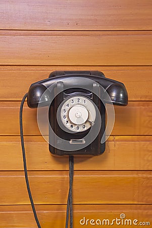 Old phone with dialer disk on wooden background Stock Photo