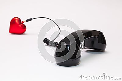 Old phone reciever and cord connection with red heart. Stock Photo