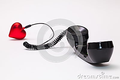 Old phone reciever and cord connection with red heart. Stock Photo