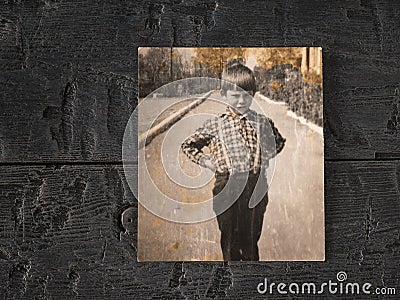 An old photograph of an injured child on a wooden table. Stylish old photo Stock Photo