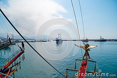 Old pirate ship on the water of Mediteranean sea. Tourist entertainment, coastal tour. Summer sunny day. Mountain shore of Alanya Stock Photo