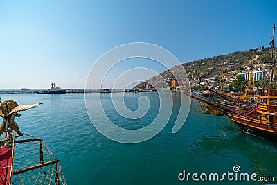 Old pirate ship on the water of Mediteranean sea. Tourist entertainment, coastal tour. Summer sunny day. Mountain shore of Alanya Stock Photo