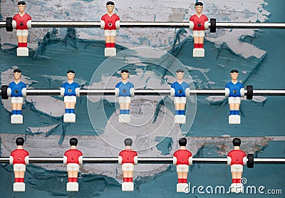 An old plastic football game with figures on sticks. The figures hang like puppets over the tattered and old football field. The Stock Photo