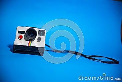 Old Polaroid camera isolated on a blue background Editorial Stock Photo