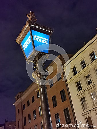 Old police street light lit up at night, London, England, UK Stock Photo