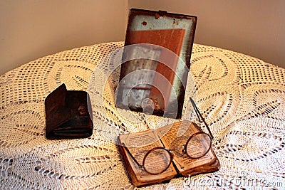 Old Polish Bible, retro spectacles and vintage mirror on a tablecloth. Old age, senility and poverty concept. Editorial Stock Photo