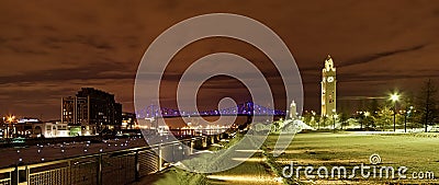 Old port of Montreal at night,with illuminated clock tower and Jacques Cartier bridge over Saint Lawrence river Editorial Stock Photo