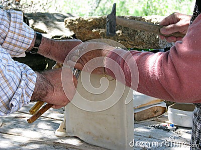 An old Portuguese couple wrapping a sheep skin around a traditional drum Stock Photo