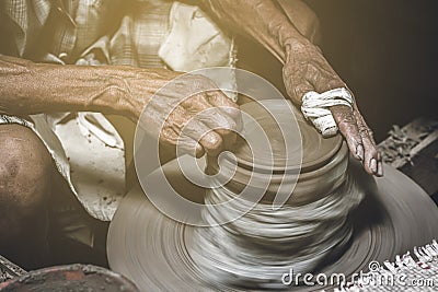 Old potter making bowl in pottery work background. Old man molding clay with handicraft Stock Photo