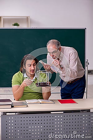 Old professor physicist and young student in the classroom Stock Photo