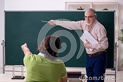 Old professor physicist and young student in the classroom Stock Photo