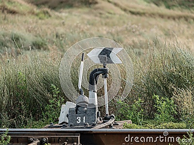 Old railroad arrow switcher. Manual rail switch mechanism. Rudiment and symbol Stock Photo