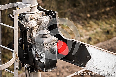 Old railway signal restored showing red stop light and lap behind mechanical gantry to light up coloured warning lens. Line closed Stock Photo