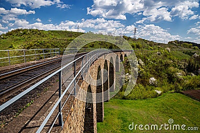 Old railway stone viaduct in the spring in sunny day Stock Photo