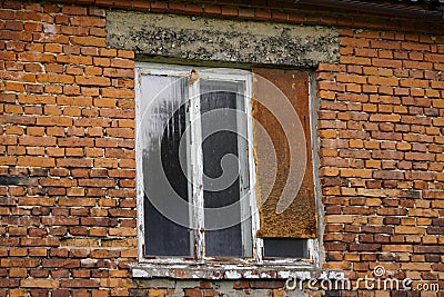 An old ramshackle red brick house by the woods, without glass or Stock Photo