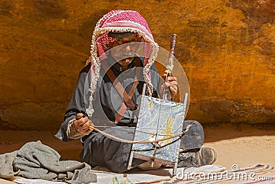 Old Rebab Bedouin player with his self made instrument singing in the Petra desert Jordan. Editorial Stock Photo