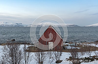 Old red boathouse at the shore of the Ullsfjord in County Troms Norway Stock Photo