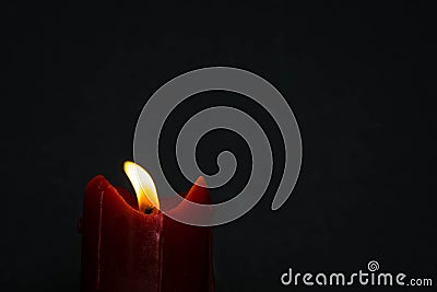 Old red candle with glimmer light flame on nice grey background, with blank upper space Stock Photo