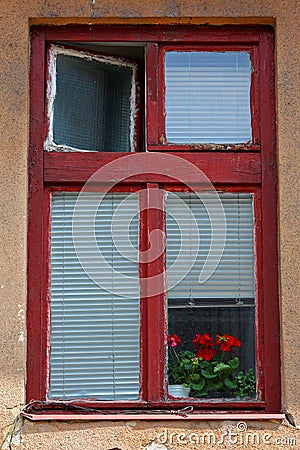 Old, red painted window frame and red geraniums. Stock Photo