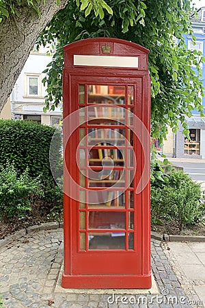Old red telephone box with a door, a bookcase with books for the population, a tourist, historical concept, architecture of Editorial Stock Photo