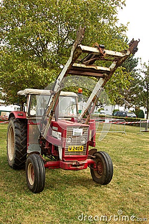 Old red tractor with lifting equipment Editorial Stock Photo