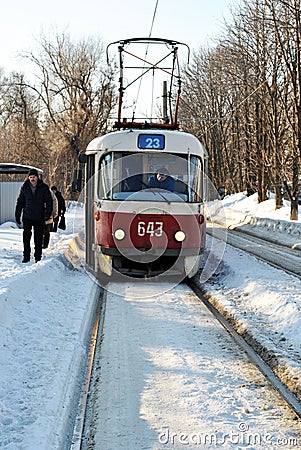 Old red tram stops in snowy park, winter sunny day Editorial Stock Photo