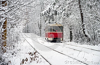 Old red yellow tram rides through the snowy forest. Winter plot. Stock Photo