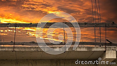 Old reinforced concrete floor with columns against the sunset sky. Dangerous abandoned building structure. Stock Photo