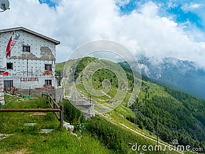 Old restaurant building to be refurbished in the mountains of Monte Baldo in Malcesine in Italy in a green meadow Editorial Stock Photo