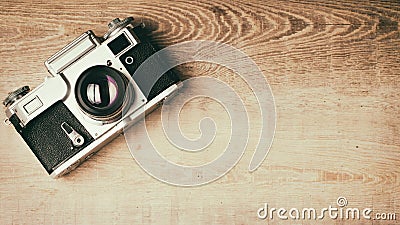 Old retro camera on vintage rustic wooden planks boards. Education photography courses back to school concept abstract background Stock Photo