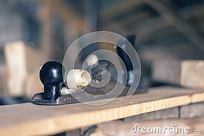 Old retro hand planer with shavings close-up on wooden Board, woodworking concept, carpentry, joinery, roofing, finishing, Stock Photo