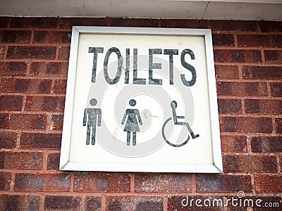 Old retro lettering sign on wall toilets male and female and dis Stock Photo