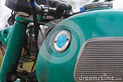 The old retro motorcycle - partial view of dirty tank with smudges of gasoline and handlebar Stock Photo